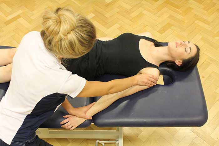 Customer receiving an arm massage while in a relaxed position in Manchester Physio Clinic Customer receiving an arm massage while in a relaxed position in Manchester Physio Clinic