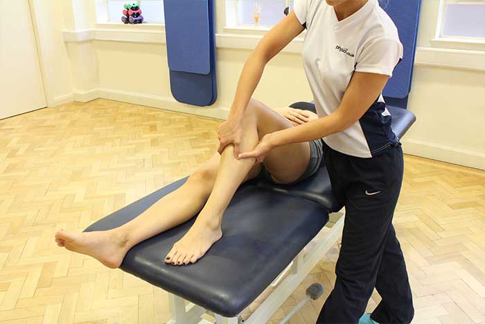 Customer receiving a calf massage while in a relaxed position in Manchester Physio Clinic Customer receiving a calf massage while in a relaxed position in Manchester Physio Clinic