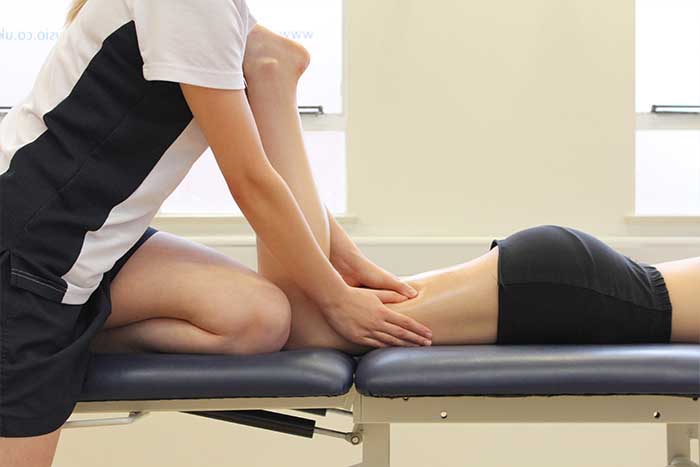 Customer receiving a thigh massage while in a relaxed position in Manchester Physio Clinic