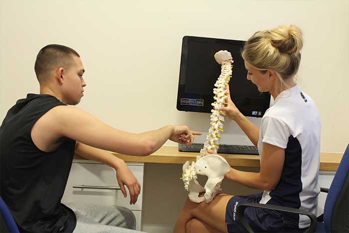 Customer going through the back areas with massager in Manchester Physio Clinic