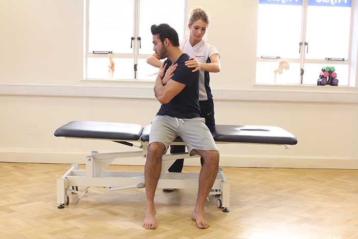 Customer reciving shoulder massage and abdominal stretches while in a sitting up position in Manchester Physio Clinic Customer reciving shoulder massage and abdominal stretches while in a sitting up position in Manchester Physio Clinic