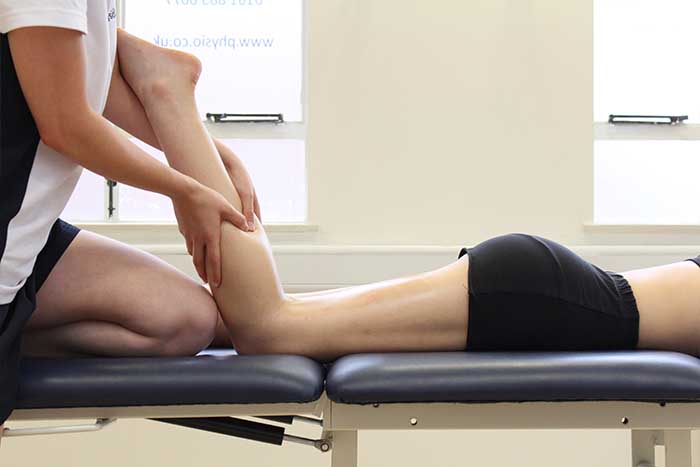 Customer receiving a calf massage while in a relaxed position in Manchester Physio Clinic