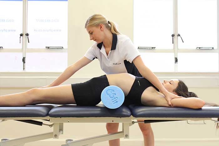 Customer receiving a back stretch while in a relaxed position in Manchester Physio Clinic Customer receiving a back stretch while in a relaxed position in Manchester Physio Clinic