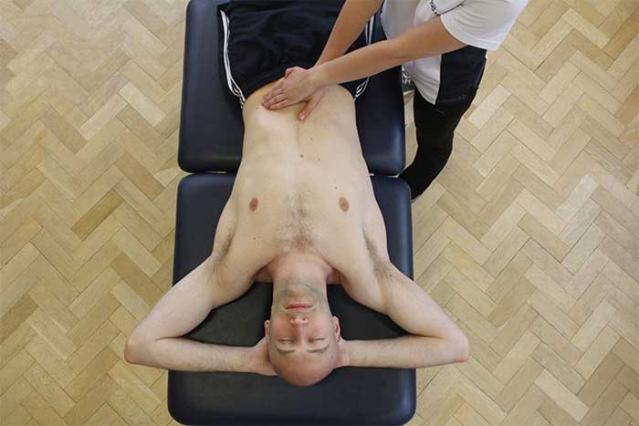Customer receiving an abdominal massage while in a relaxed position in Manchester Physio Clinic Customer receiving an abdominal massage while in a relaxed position in Manchester Physio Clinic