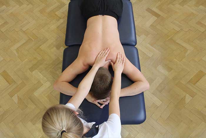 Customer receiving a shoulder massage while in a relaxed position in Manchester Physio Clinic Customer receiving a shoulder massage while in a relaxed position in Manchester Physio Clinic