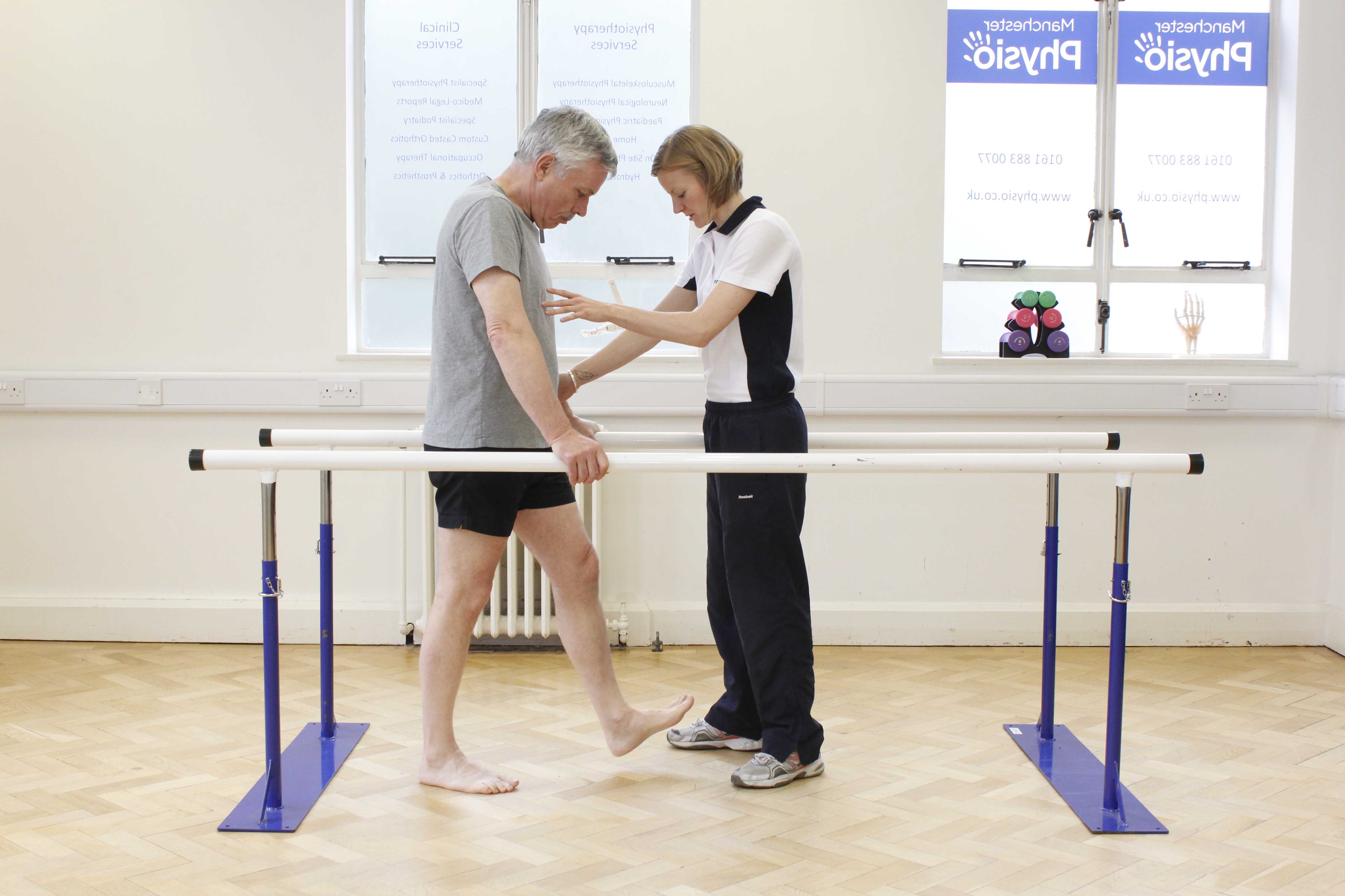 Mobility exercises between the parallel bars assisted by specialist neurological physiotherapist Mobility exercises between the parallel bars assisted by specialist neurological physiotherapist