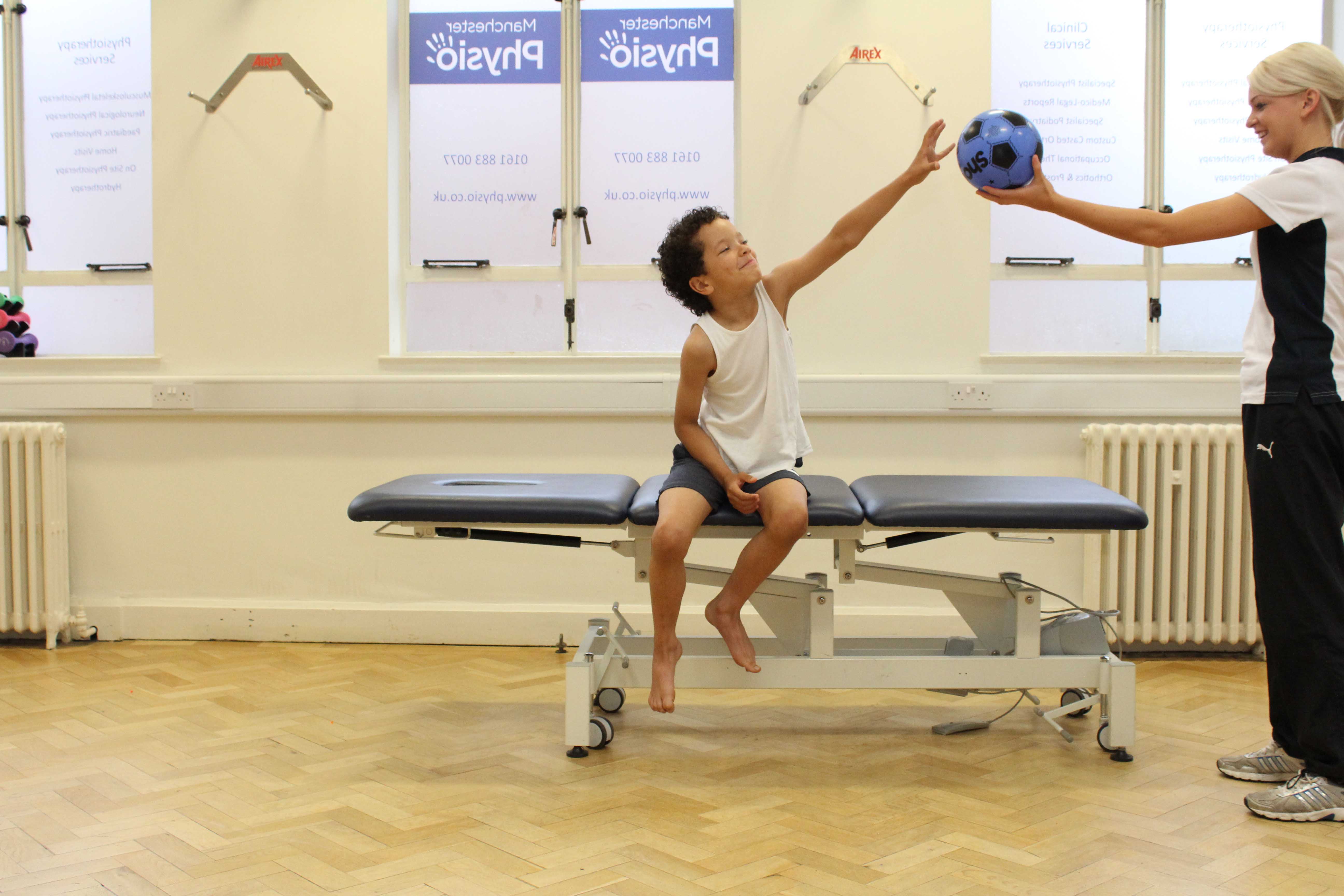 Physiotherapist assessing postural stability during movement using reaching exercises
