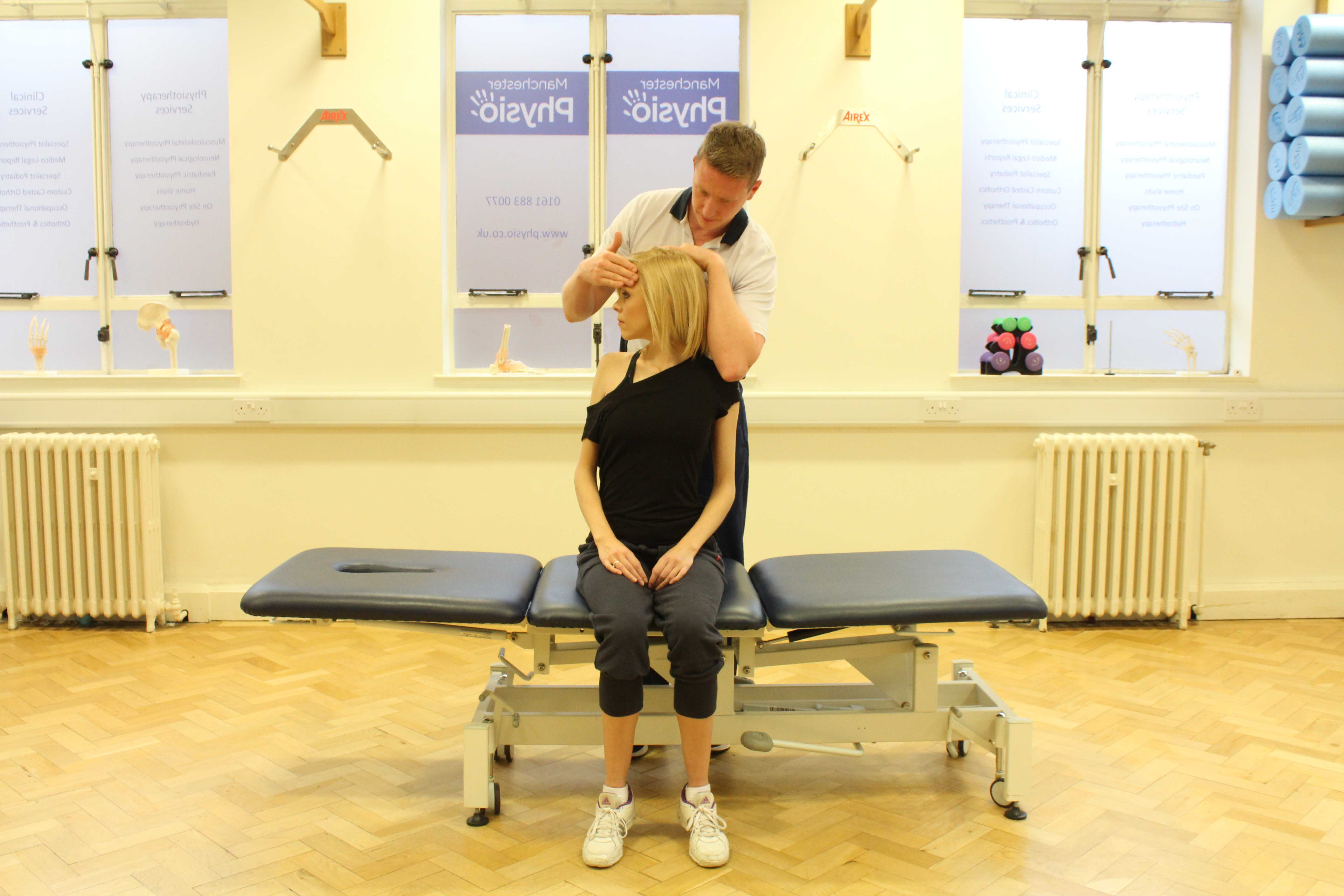 Experienced Physiotherapist conducting an assessment of the cervical spine, muscles and connective tissues in the neck Experienced Physiotherapist conducting an assessment of the cervical spine, muscles and connective tissues in the neck