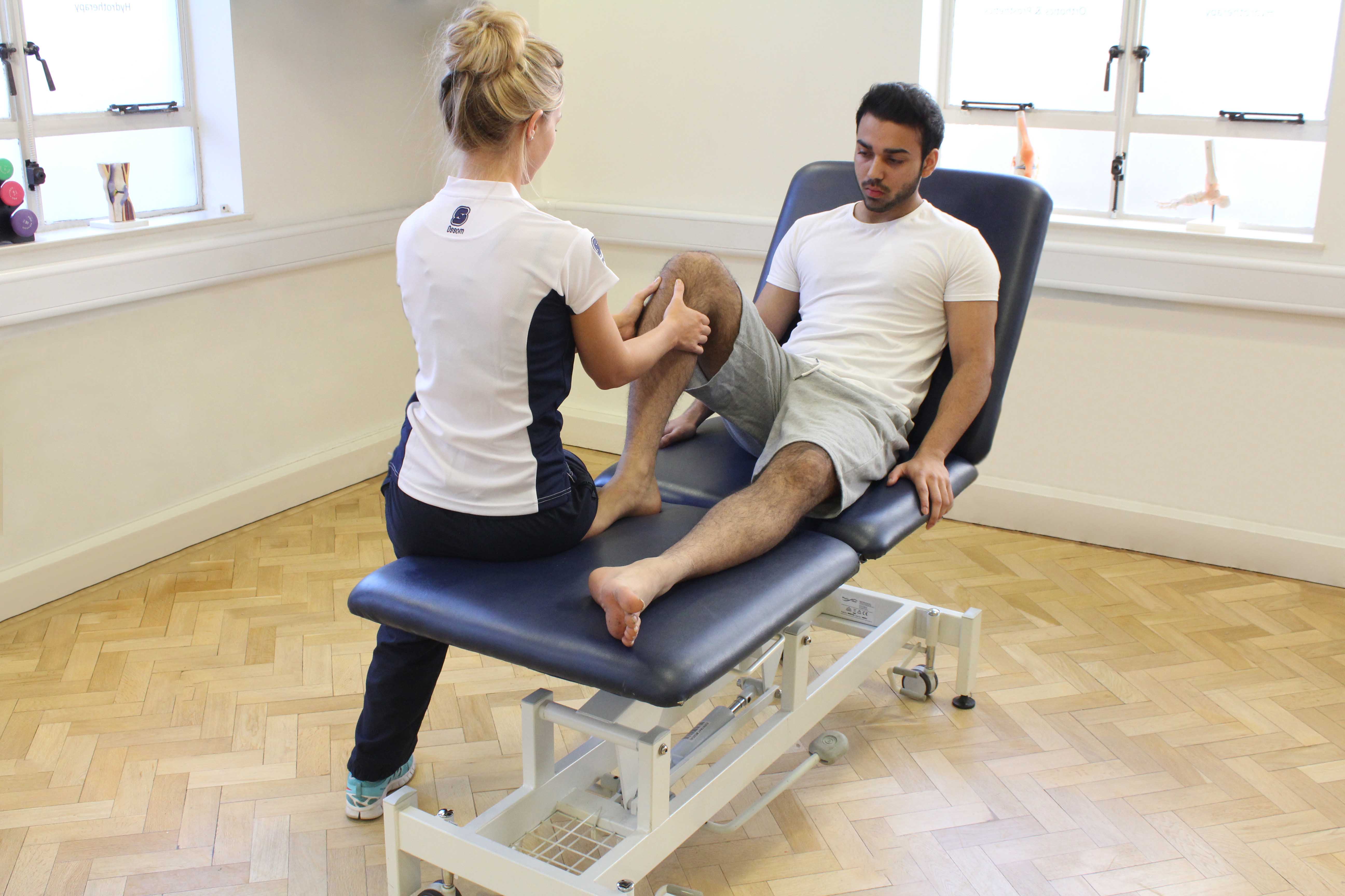 Therapist performing knee assessment