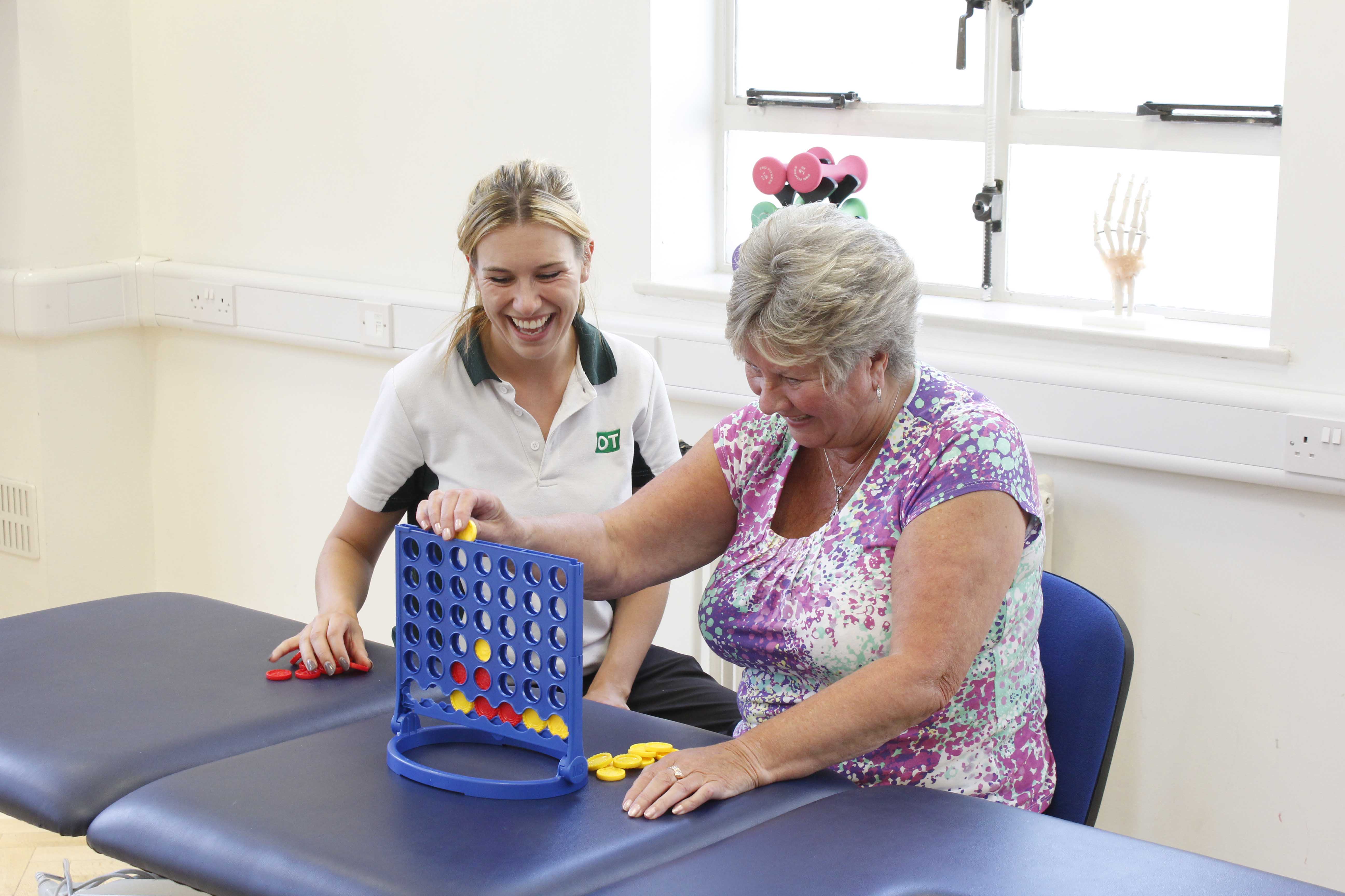 Occupational therapist supervising functional fine motor skill exercises Occupational therapist supervising functional fine motor skill exercises