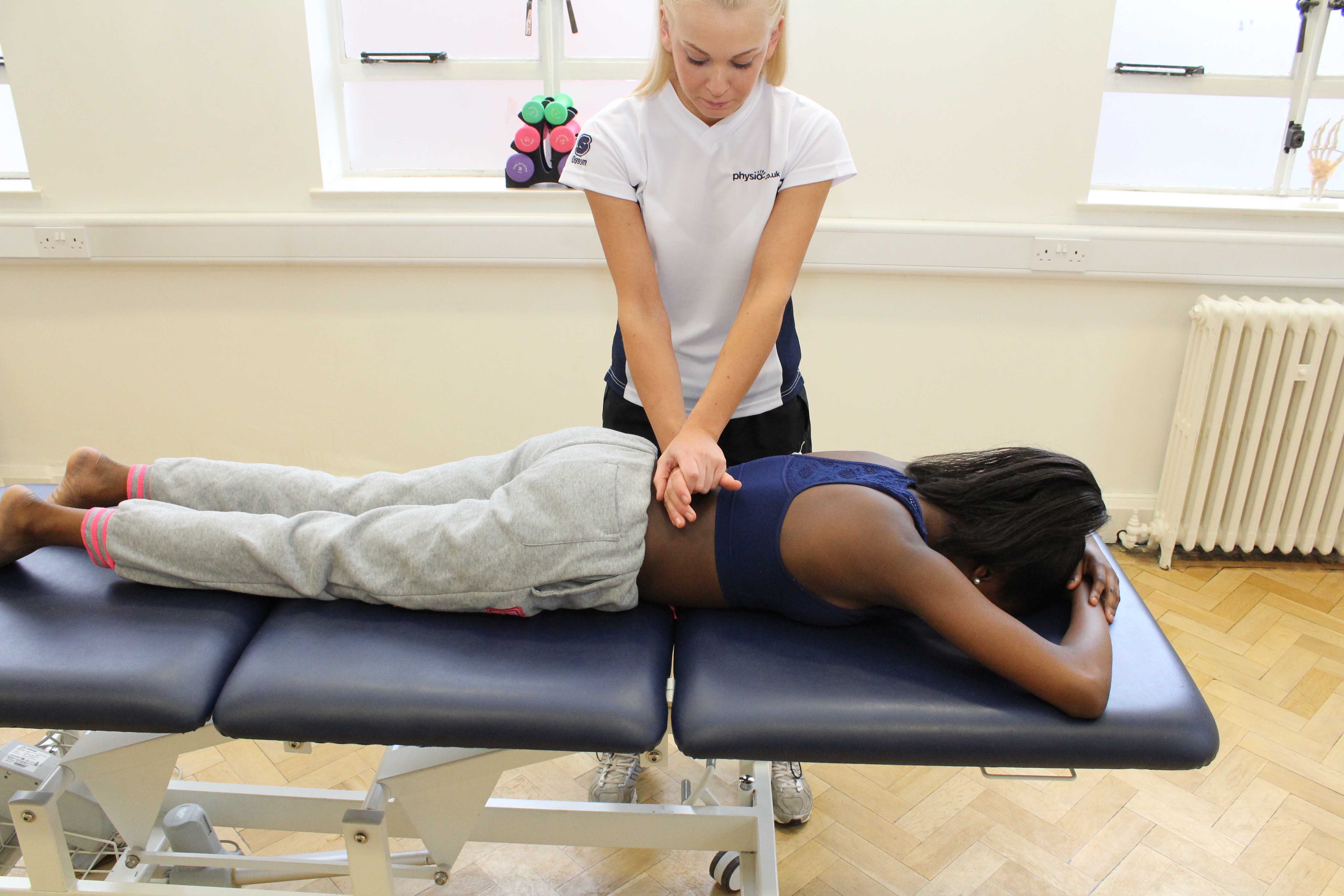 Mobilisations of the lumber vertebrea by physiotherapist to relieve pain and stiffness