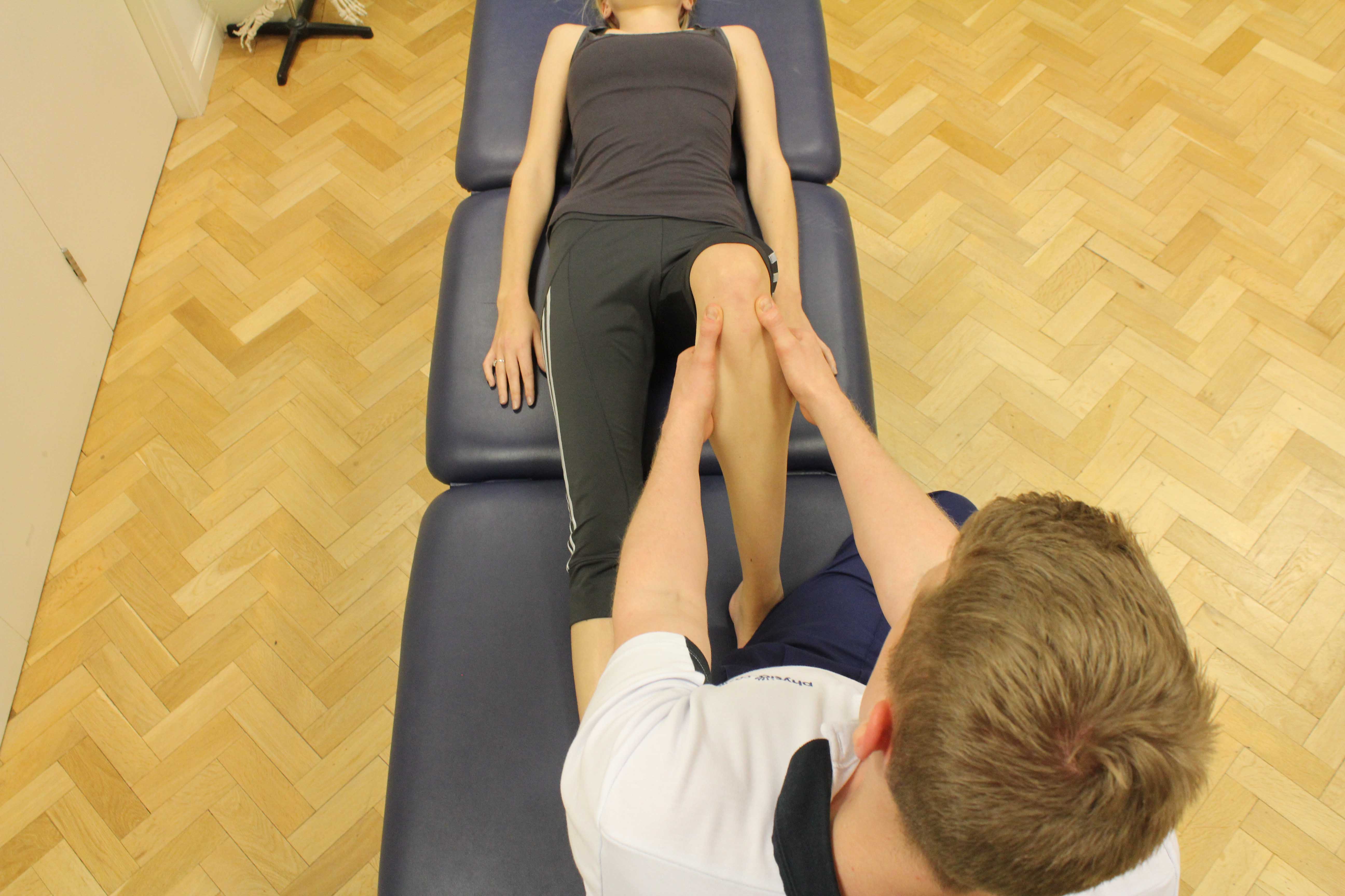 Therapist performing knee assessment