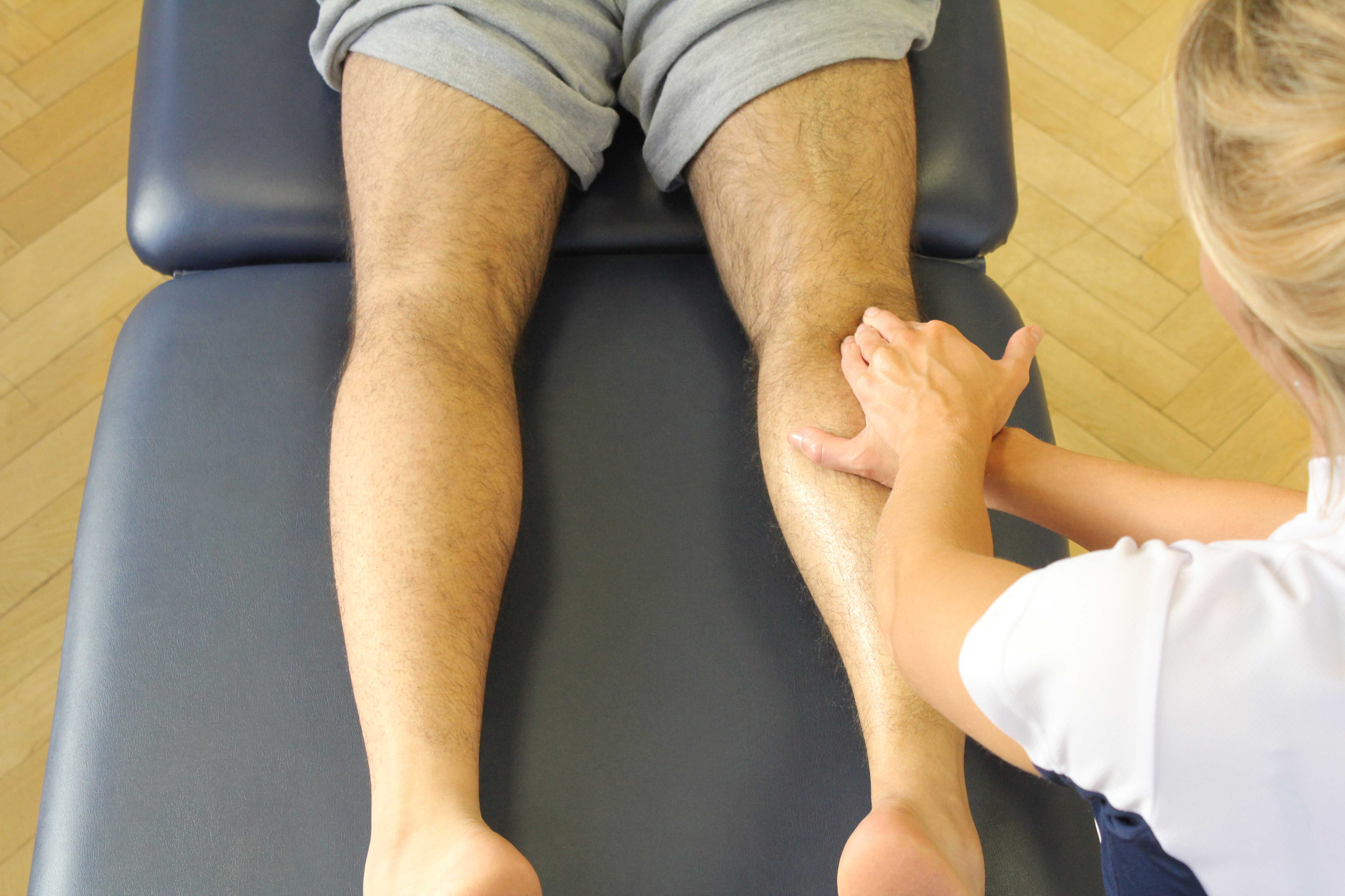 Therapist performing soft tissue massage on the tissues aound the knee Therapist performing soft tissue massage on the tissues aound the knee