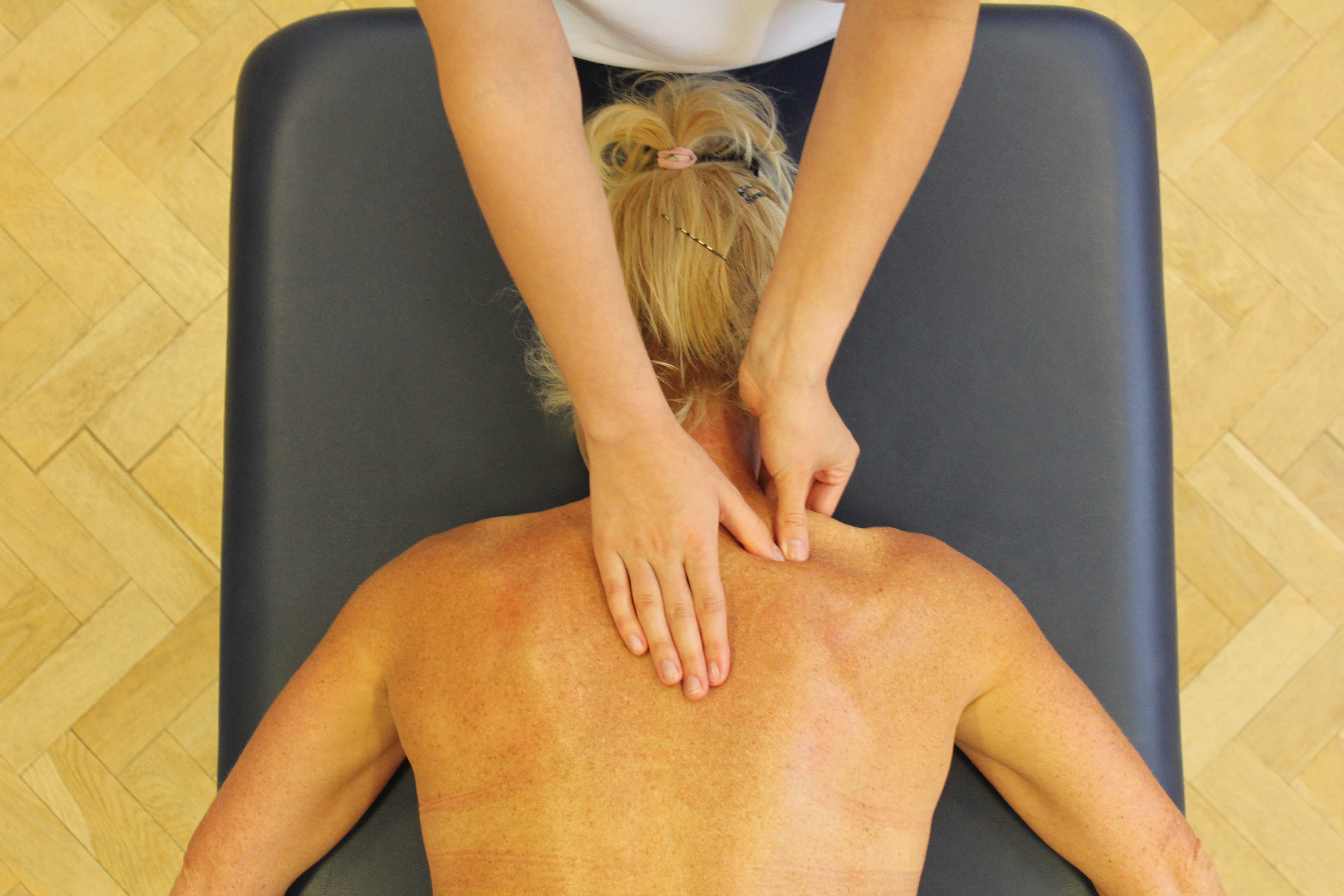 Trigger point massage of the trapezius muscle by a therapist Trigger point massage of the trapezius muscle by a therapist