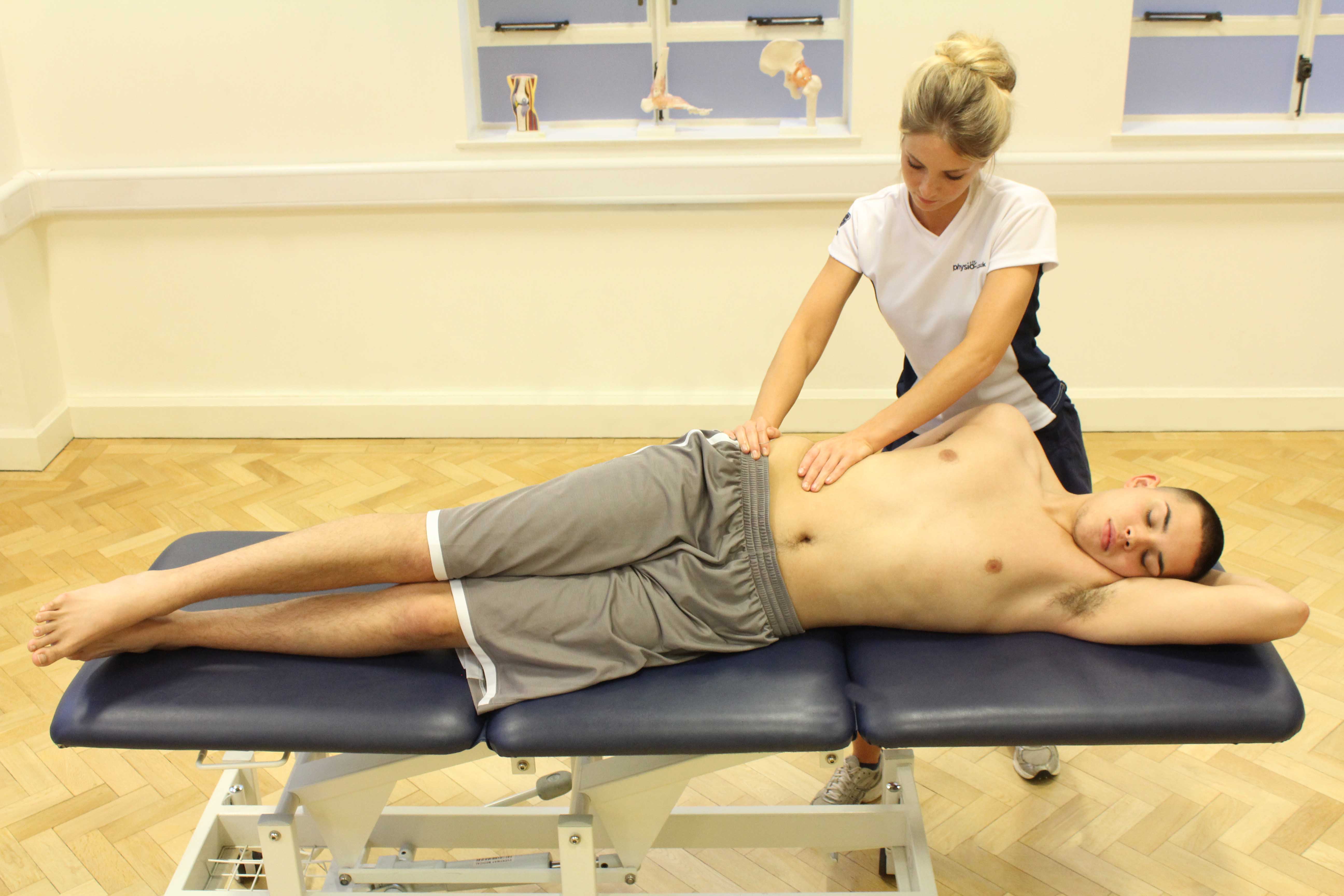 Soft tissue massage of the abdominal muscles by an experienced therapist