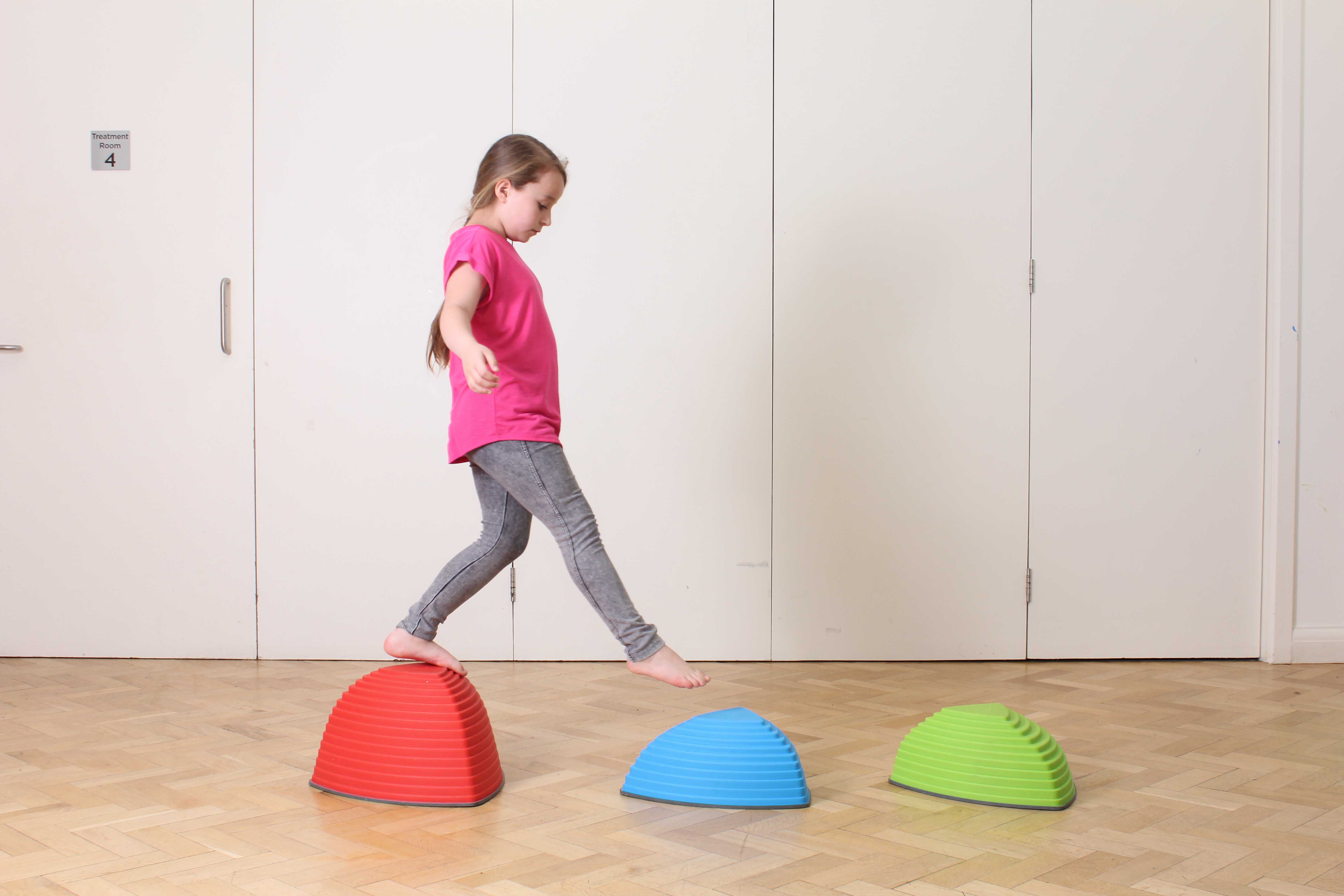 Paediatric neuro physiotherapist supervising mobility exercises with a wheeled walking frame