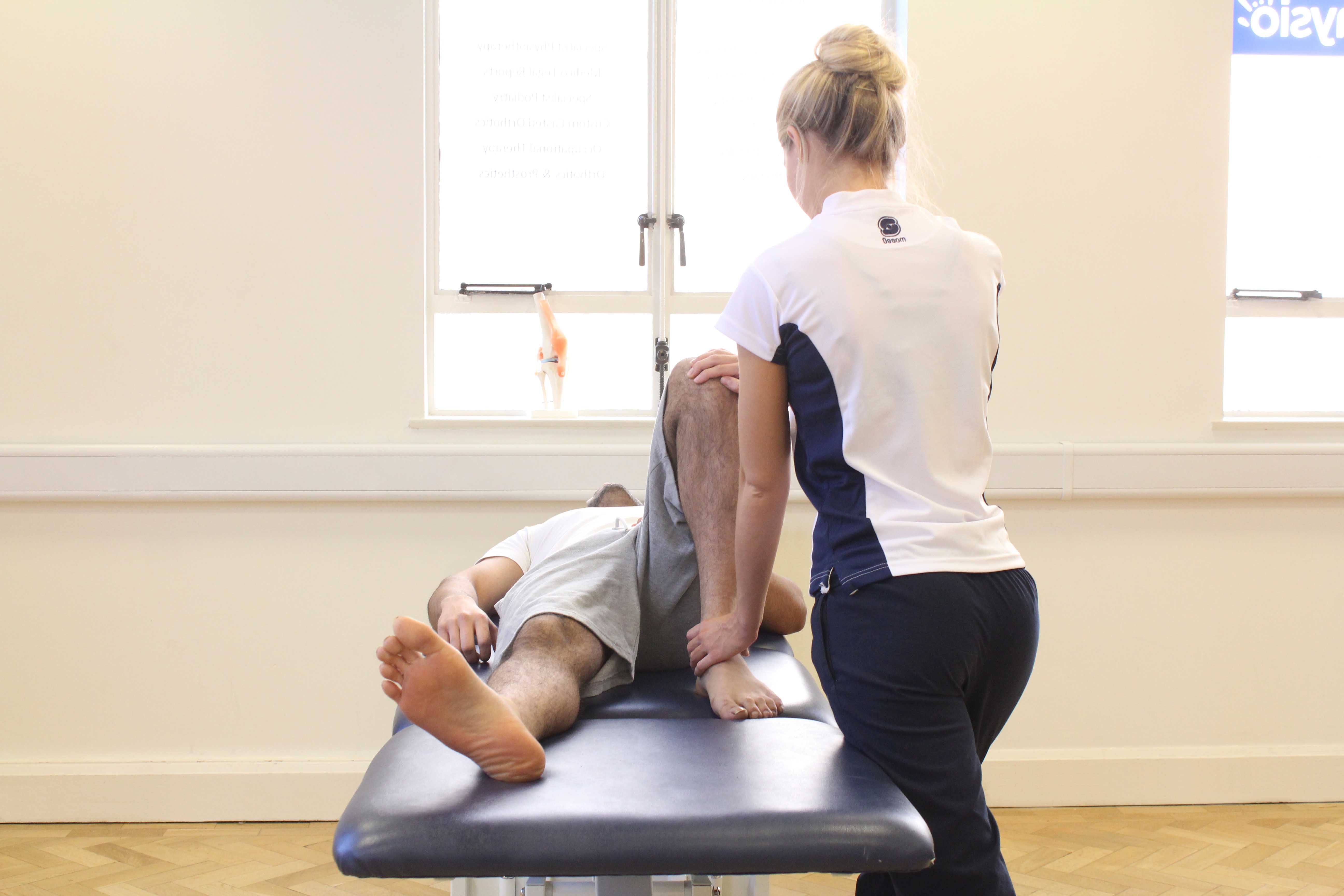 Therapist performing knee assessment