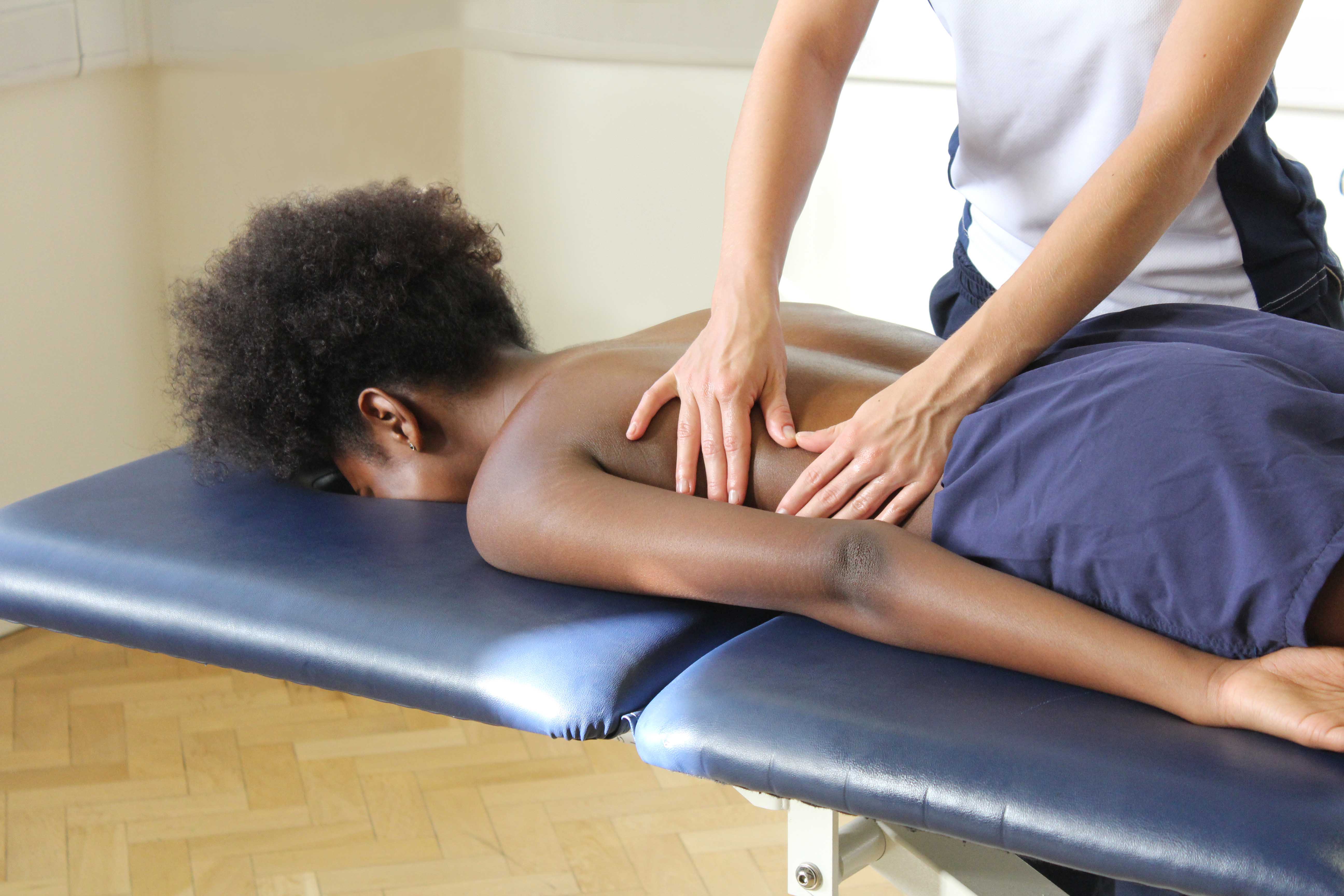 Rolling soft tissue massage of the lower back to relieve stiffness and reduce muscle spasm