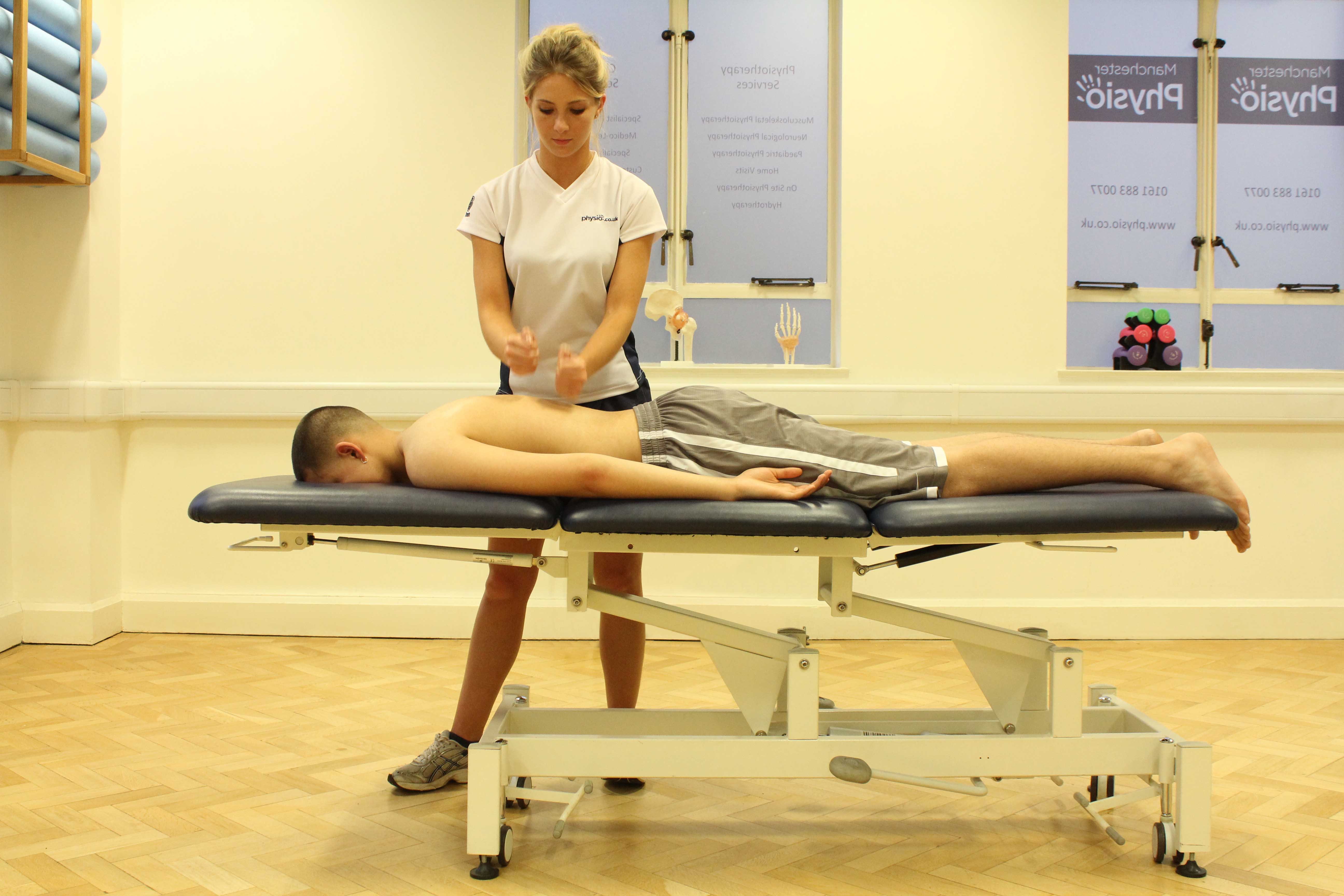 Sports massage focused on latissimus dorsi muscle using percussion technique