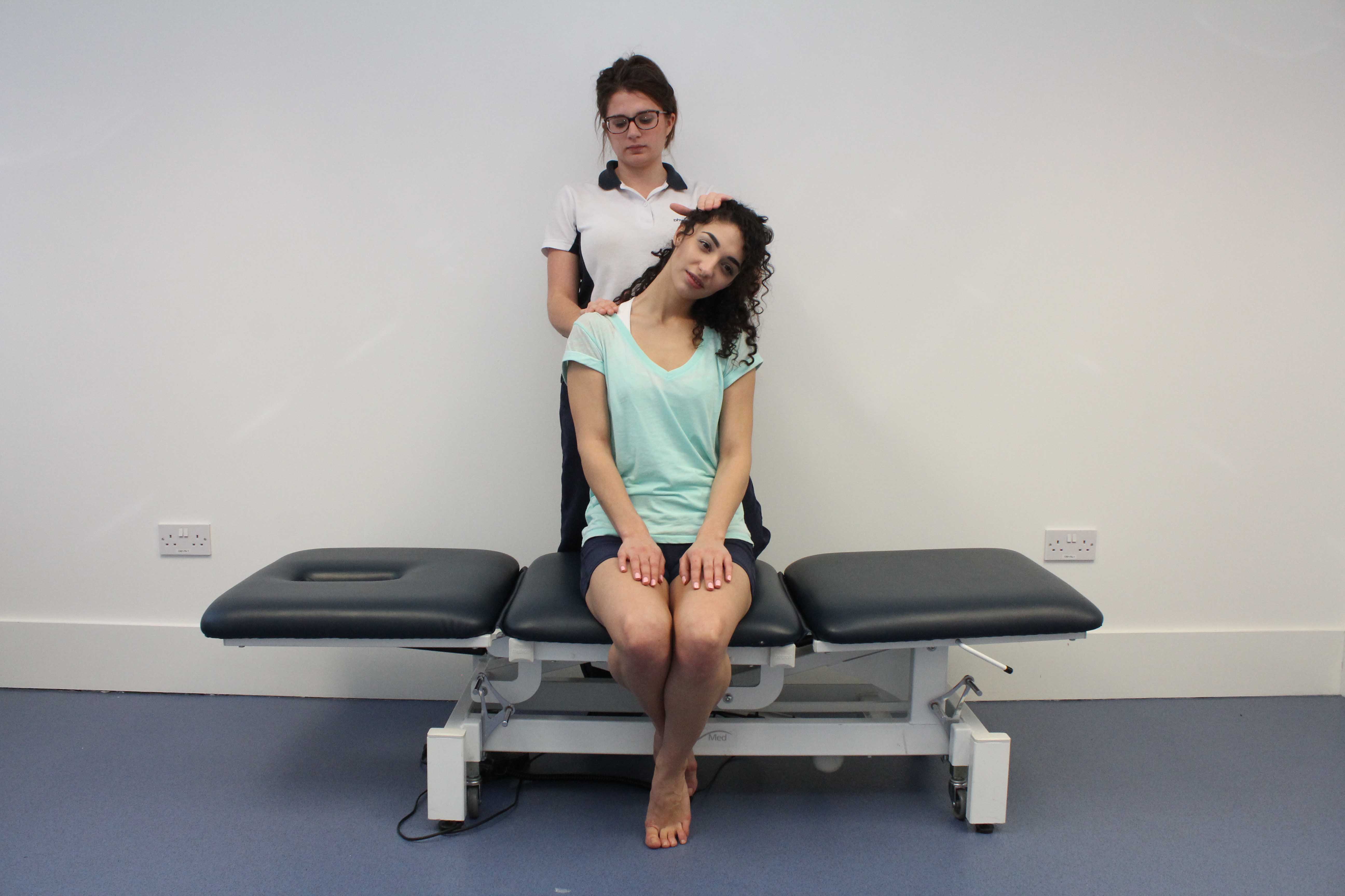 Stretches applied to the trapezius muscle and connective tissues in the neck by physiotherapist