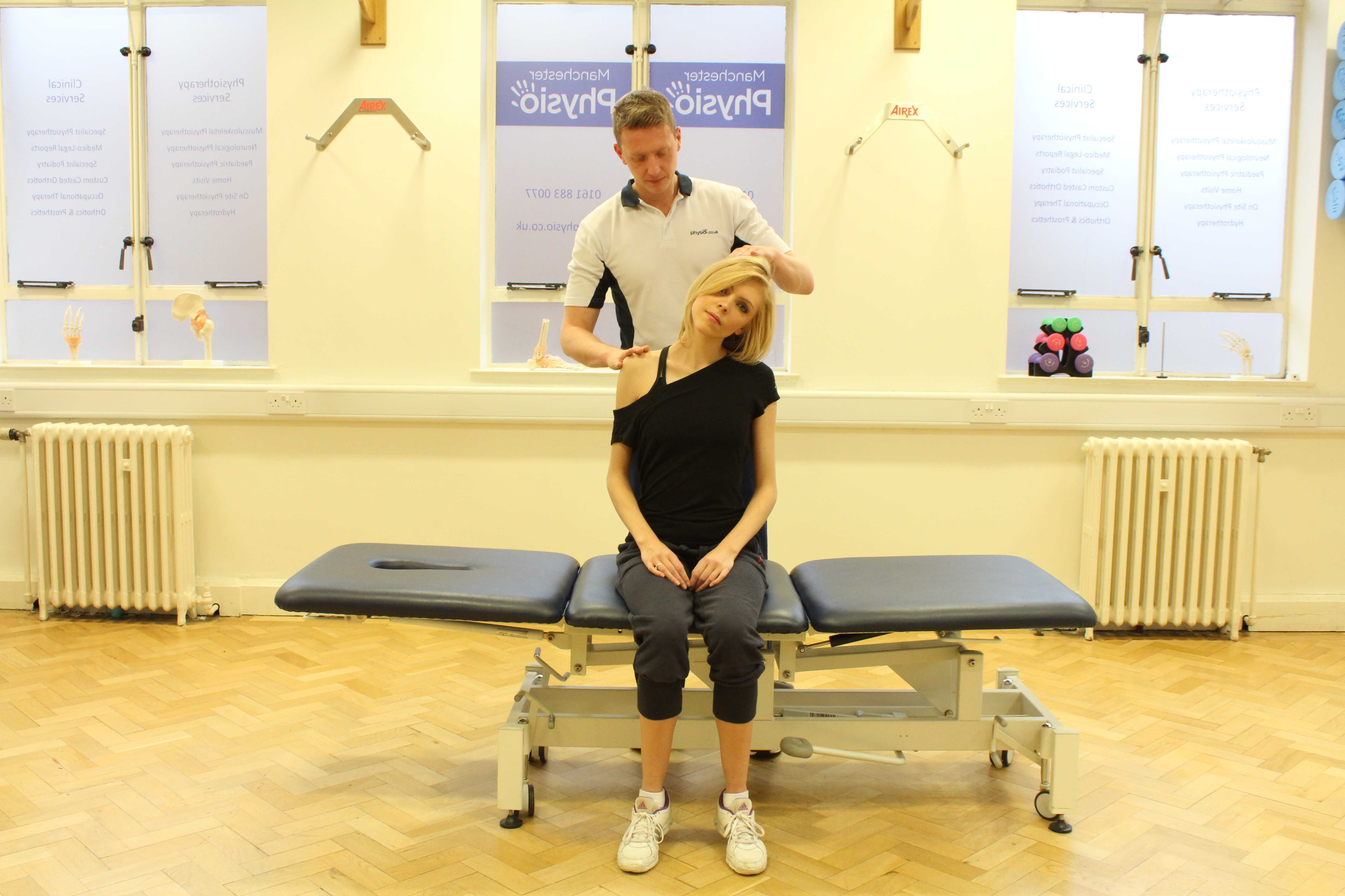 Experienced Physiotherapist conducting an assessment of the cervical spine, muscles and connective tissues in the neck Experienced Physiotherapist conducting an assessment of the cervical spine, muscles and connective tissues in the neck