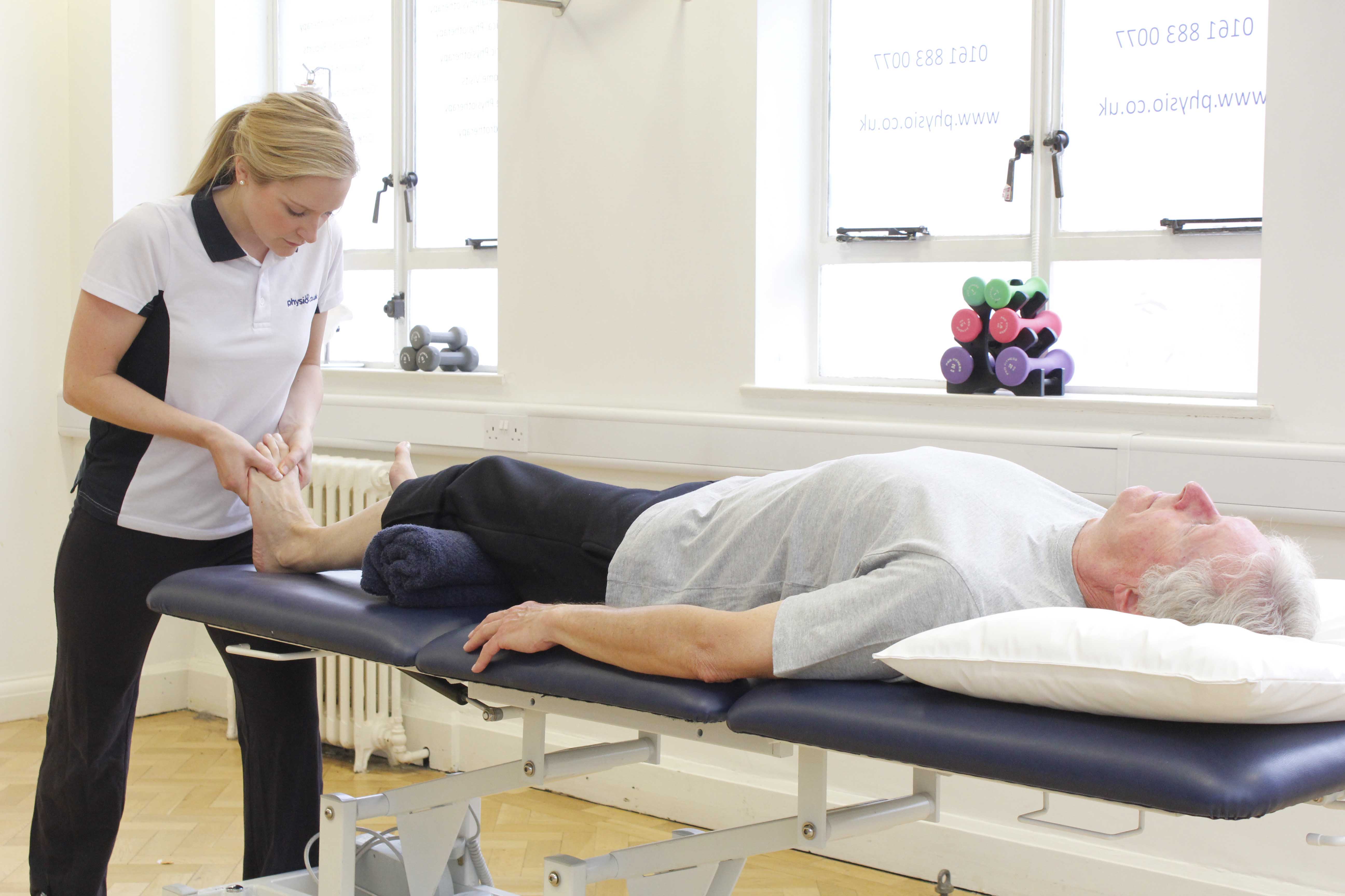 Physiotherapist mobilisaing the metatarsal joints in the foot to relieve stiffness and aching