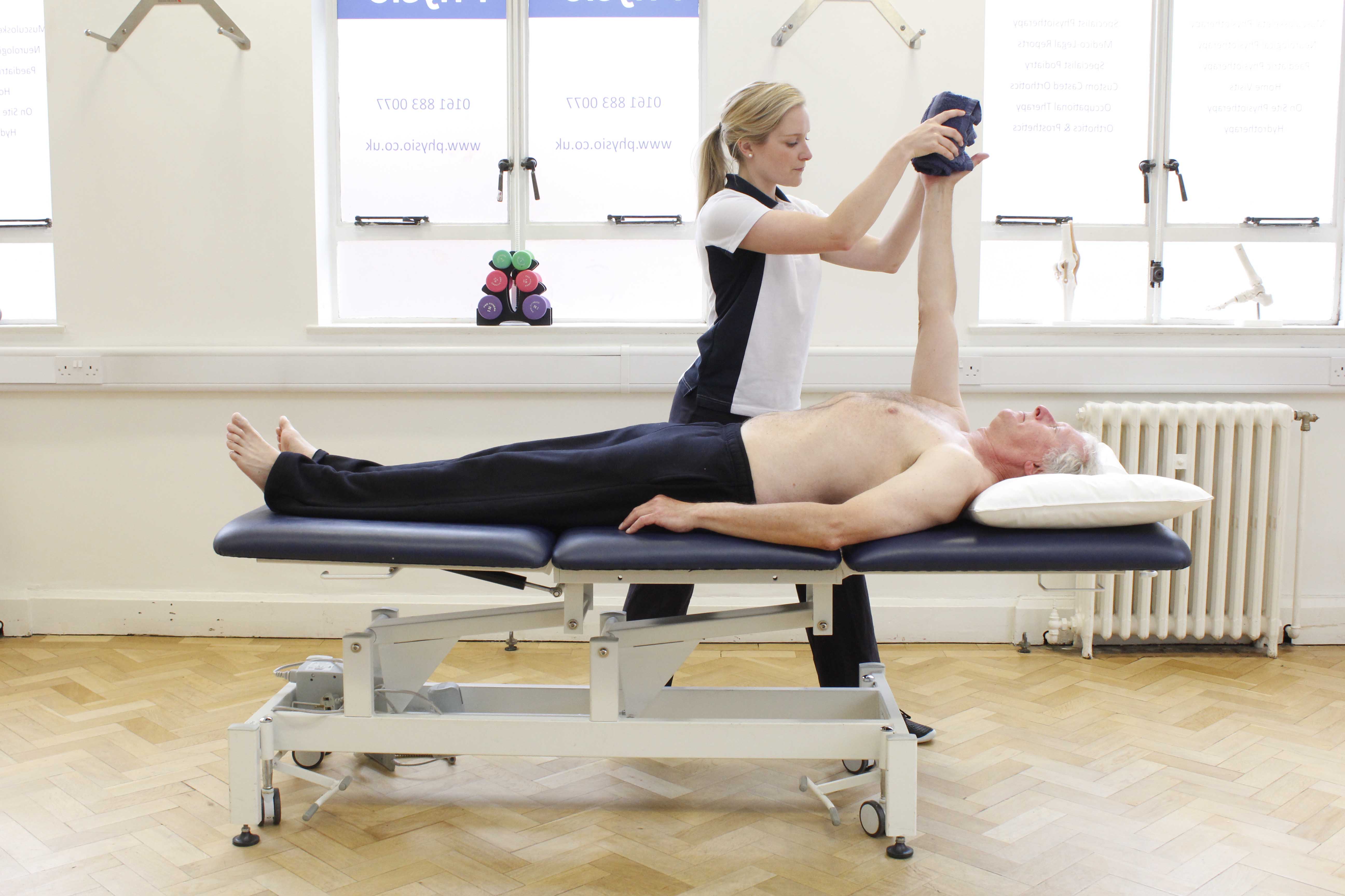 Specialist musculoskeletal physiotherapist assessing available mobility of the shoulder joint