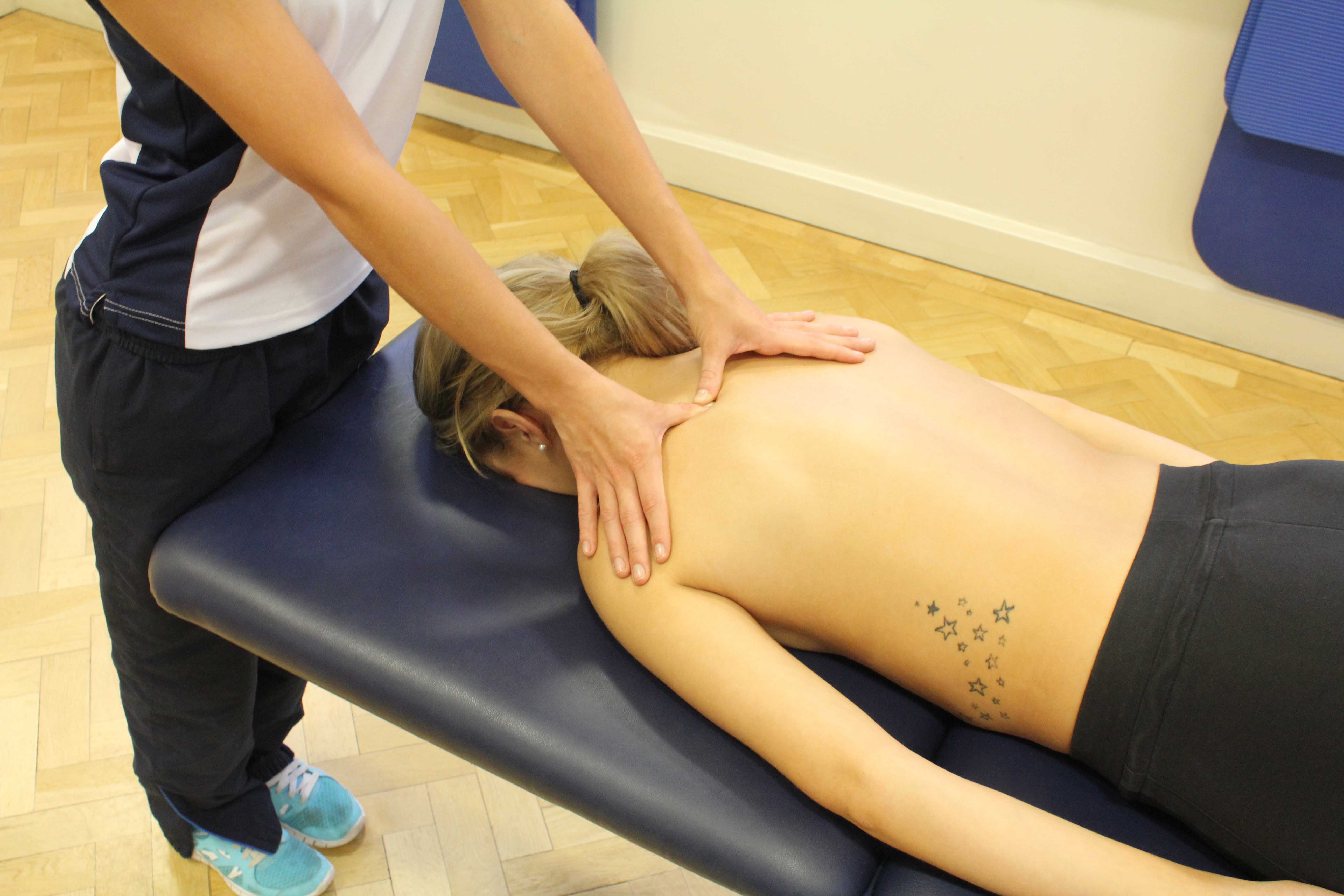 Trigger point massage of the muscles in the upper back by experienced therapist Trigger point massage of the muscles in the upper back by experienced therapist