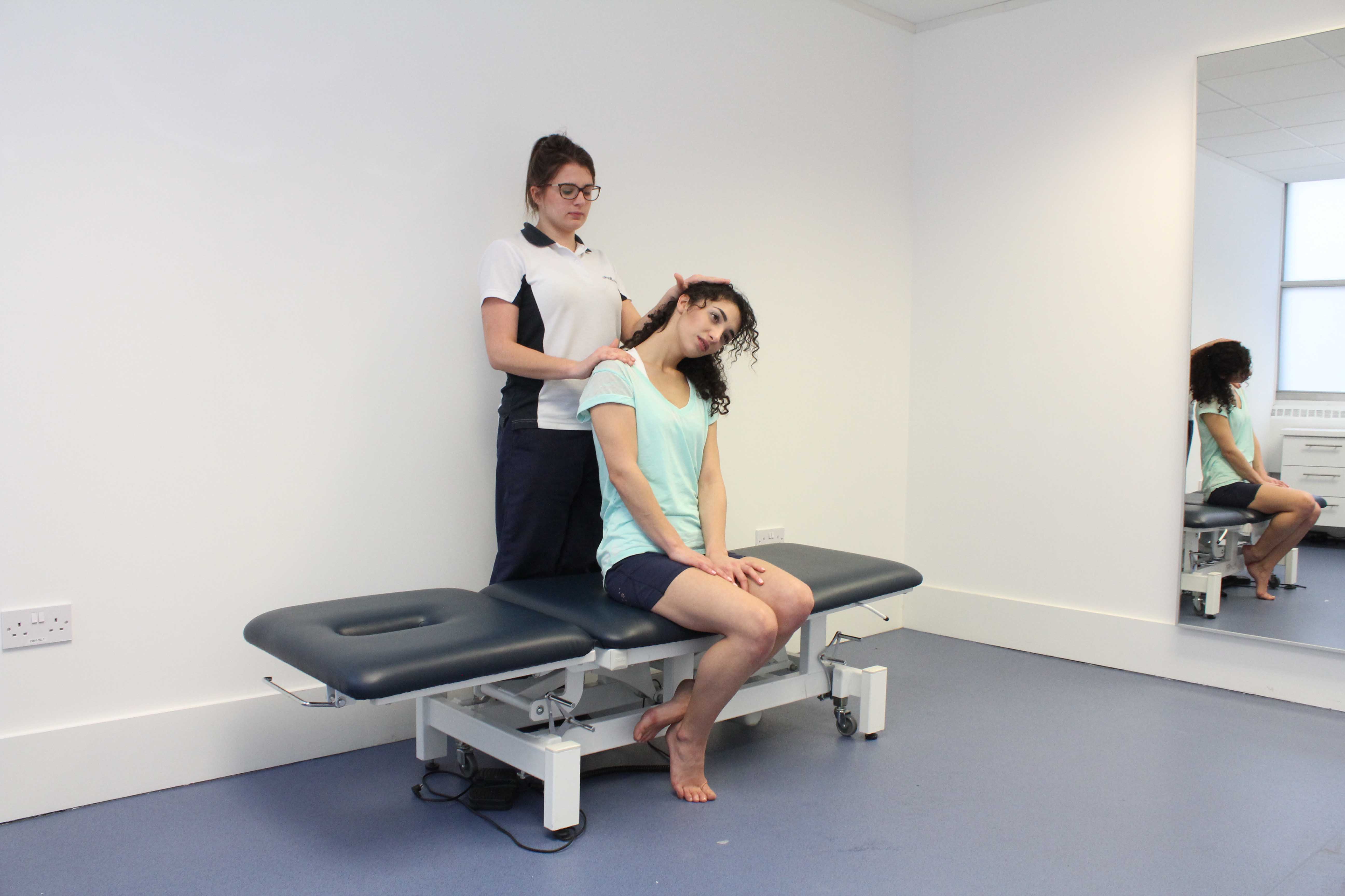 Stretches applied to the trapezius muscle and connective tissues in the neck by physiotherapist