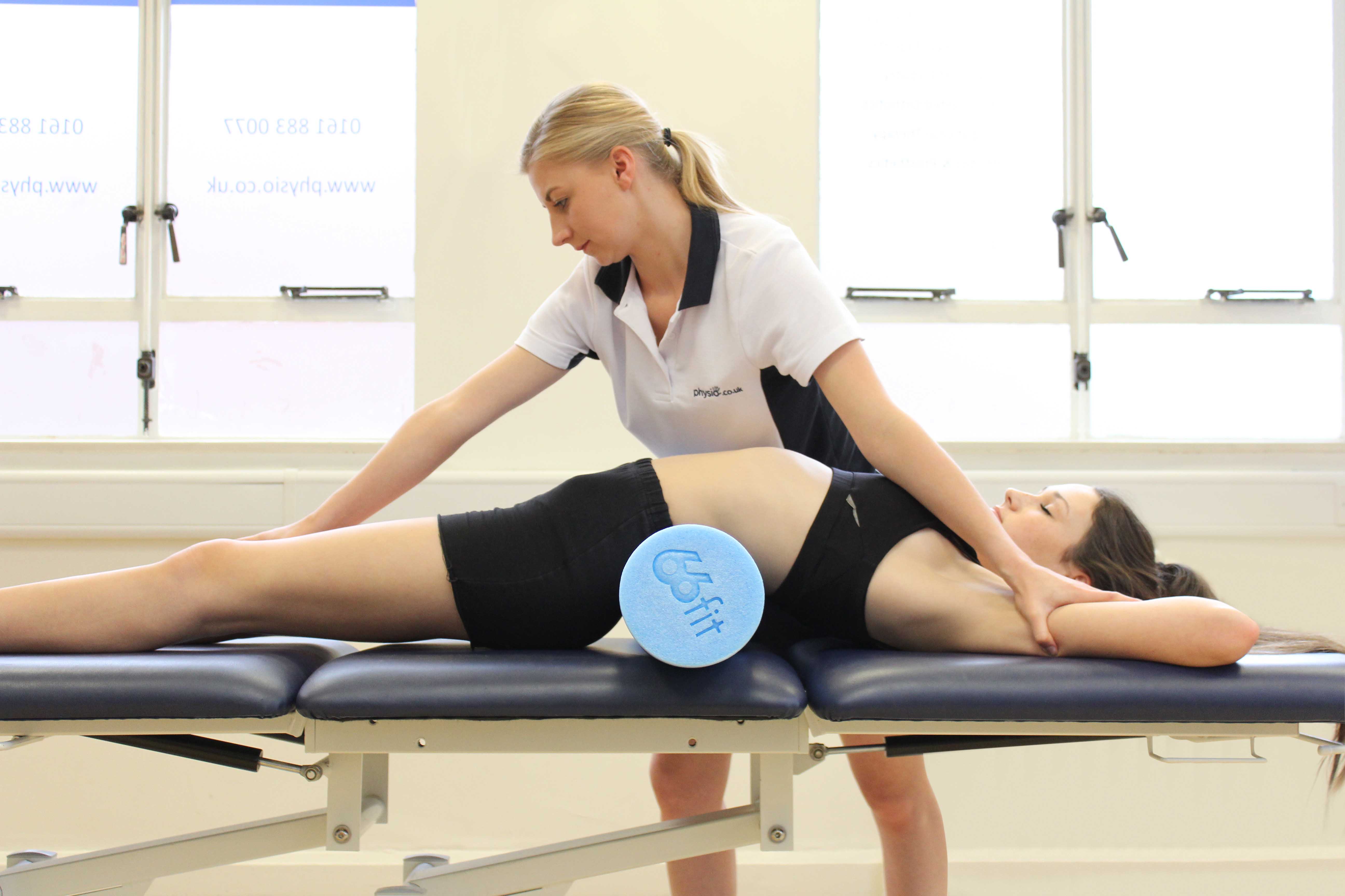 Therapist using a foam roller to increase the efficacy of applied traction Therapist using a foam roller to increase the efficacy of applied traction